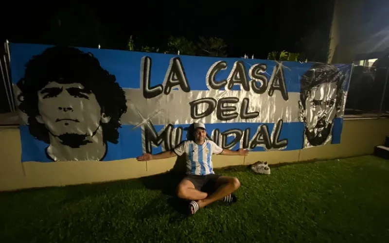 La "Casa del Mundial": la historia de 10 amigos que se fueron a vivir juntos durante todo un mes y a ver todos los partidos Tienen una icónica bandera con las caras de Lionel Messi y Diego Maradona.